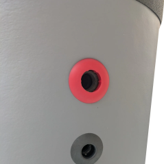 Détail d'un orifice de raccordement de l'eau chaude avec insert de couleur rouge.